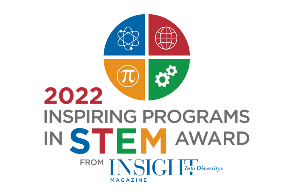 Circle divided into four different-colored quadrants. The upper left quadrant has a blue background with a white atom icon, the upper right is red with a white world wide web symbol, the bottom left is yellow with a white pi symbol, and the bottom right quadrant is green with white gear icons on it. Text below says "2022 Inspiring Programs in STEM Award from INSIGHT Into Diversity Magazine."