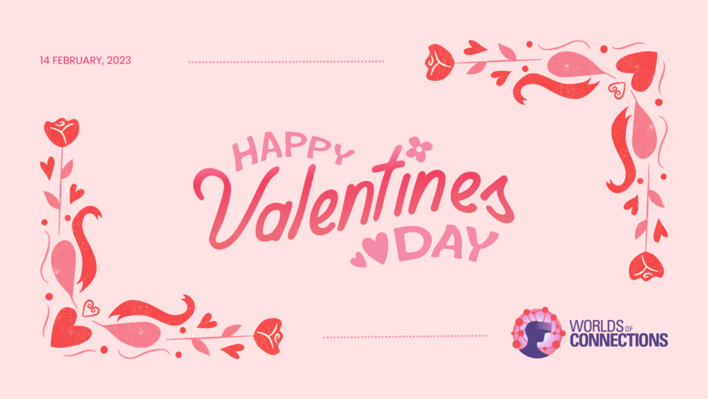 Light pink background with a red-and-pink corner detail with hearts and roses. The message "HAPPY VALENTINE'S DAY" is in the center in large script, and the date "14 FEBRUARY, 2023" is in the upper left corner. The purple "Worlds of Connections" logo featuring a person wearing a VR headset is in the lower right corner.